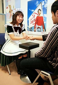 Akiba maid gives hand massage to blood donor